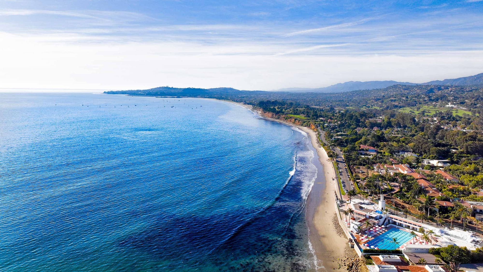 The Montecito coastline from above, with blue water and the mountains behind